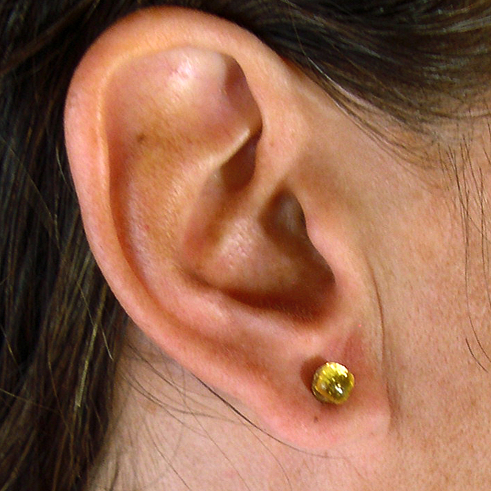 The tiny stud earring (K05ES) on a model.